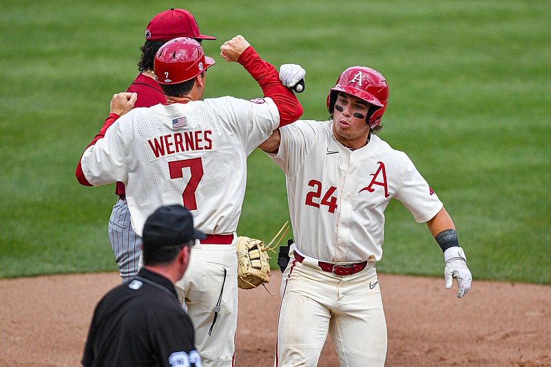 Arkansas second baseman Peyton Holt (24) celebrates with first-base coach Bobby Wernes after hitting the team’s first base hit of the game, Sunday, May 14, 2023, during the third inning of the Razorbacks’ 5-1 win over the South Carolina Gamecocks at Baum-Walker Stadium in Fayetteville. Visit nwaonline.com/photo for today's photo gallery..(NWA Democrat-Gazette/Hank Layton)