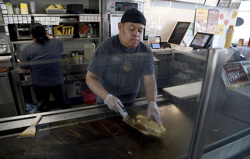 Ricardo Acosta prepares food at a Taco John’s restaurant in Denver on Tuesday.
(AP/Thomas Peipert)