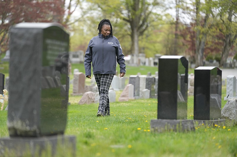Debra Long walks near the tombstone of her son, Randy Long, in Poughkeepsie, N.Y., April 19, 2023. An AP examination of data from 23 states shows that Black people are disproportionately denied aid from programs that reimburse victims of violent crime. (AP Photo/Seth Wenig)