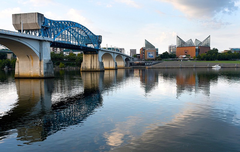 Staff Photo by Robin Rudd / The rising run illuminates the underside of the Market Street Bridge, as the 105 year-old span carries the morning traffic in August 2022. At right, stands the Tennessee Aquarium that fueled the riverfront's rebirth when it opened in 1992.