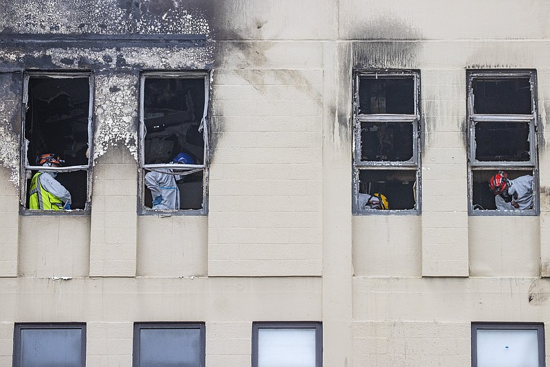 Fire and Police investigators inspect inside the Loafers Hostel in Wellington, New Zealand on Thursday.
(AP/New Zealand Herald/George Heard)