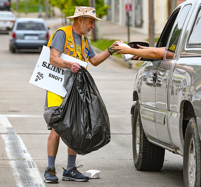 Jefferson City Host Lion Bruce Berger sells peanuts to a driver at the intersection of Dunklin and Madison streets Friday morning as part of the annual Host Lions Club Dusty Deskins Peanut Day. Berger and a couple of dozen of the club members took to the southside and downtown streets and sidewalks early in the morning to try to raise the most money possible for local Lions Club causes.