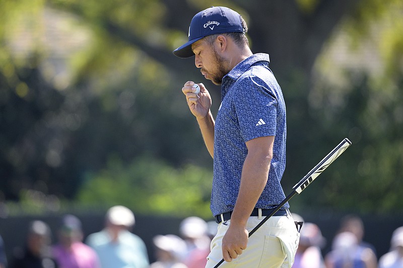 Xander Schauffele blows on his ball after making a putt for birdie on the first green during the first round of the Arnold Palmer Invitational golf tournament, Thursday, March 2, 2023, in Orlando, Fla. (AP Photo/Phelan M. Ebenhack)