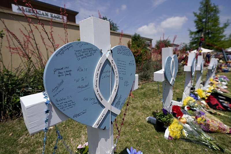 In this May 8, 2023, photo, A cross with a name Christian LaCour written at the center, stands by others representing each of the victims of a mass shooting at a makeshift memorial in Allen, Texas. (AP Photo/Tony Gutierrez, file)