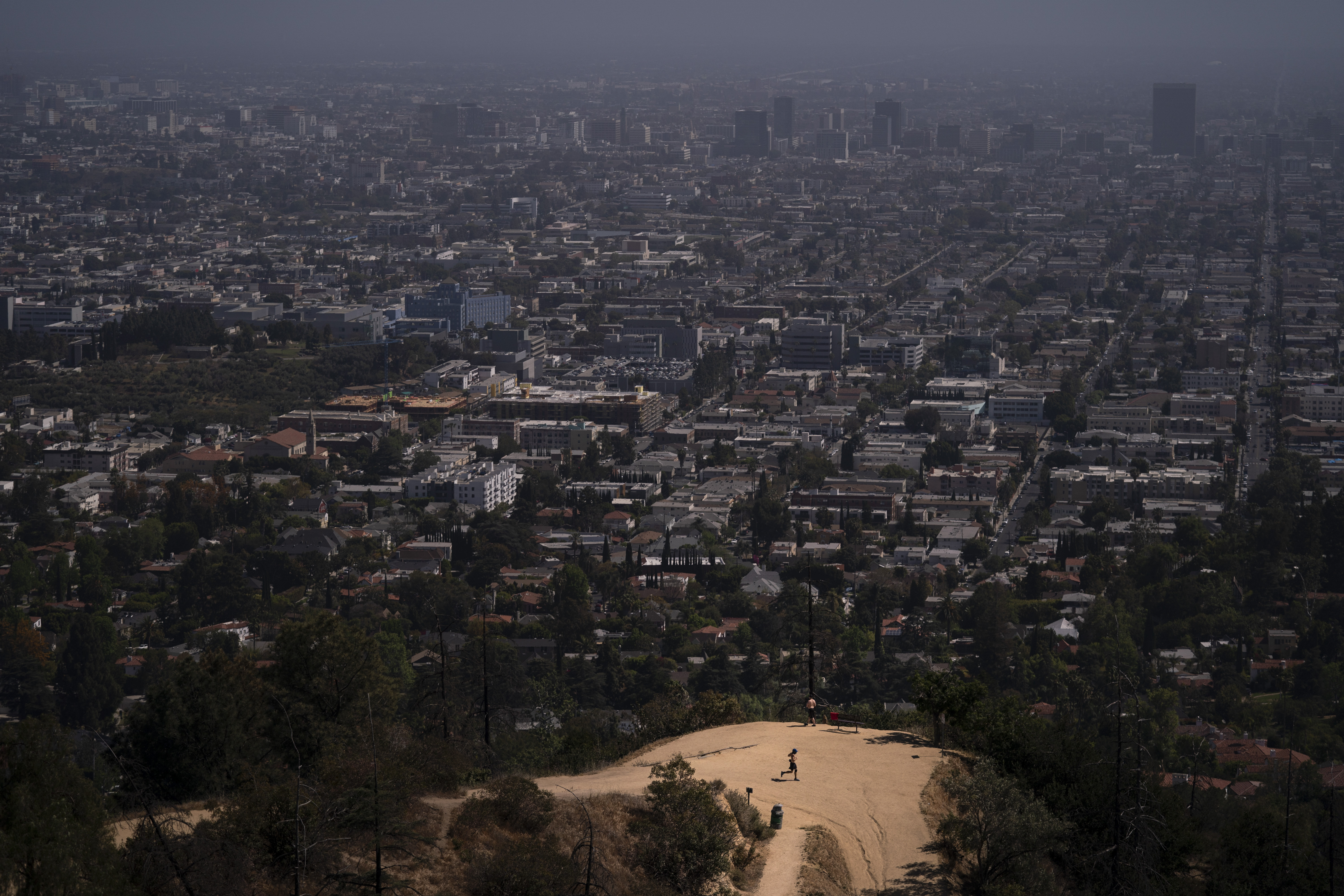 FILE - A jogger runs along a trail in Griffith Park in Los Angeles, May 3, 2021. In May 2023, U.S. Surgeon General Vivek Murthy declared loneliness an American epidemic, saying that it takes as deadly a toll as smoking upon the population of the United States. Solitude and isolation do not automatically equal loneliness, but with additional recent stressors — the rise of social media and virtual life, post-9/11 polarization and the way COVID-19 interrupted existence — the challenge becomes even more stark. (AP Photo/Jae C. Hong, File)
