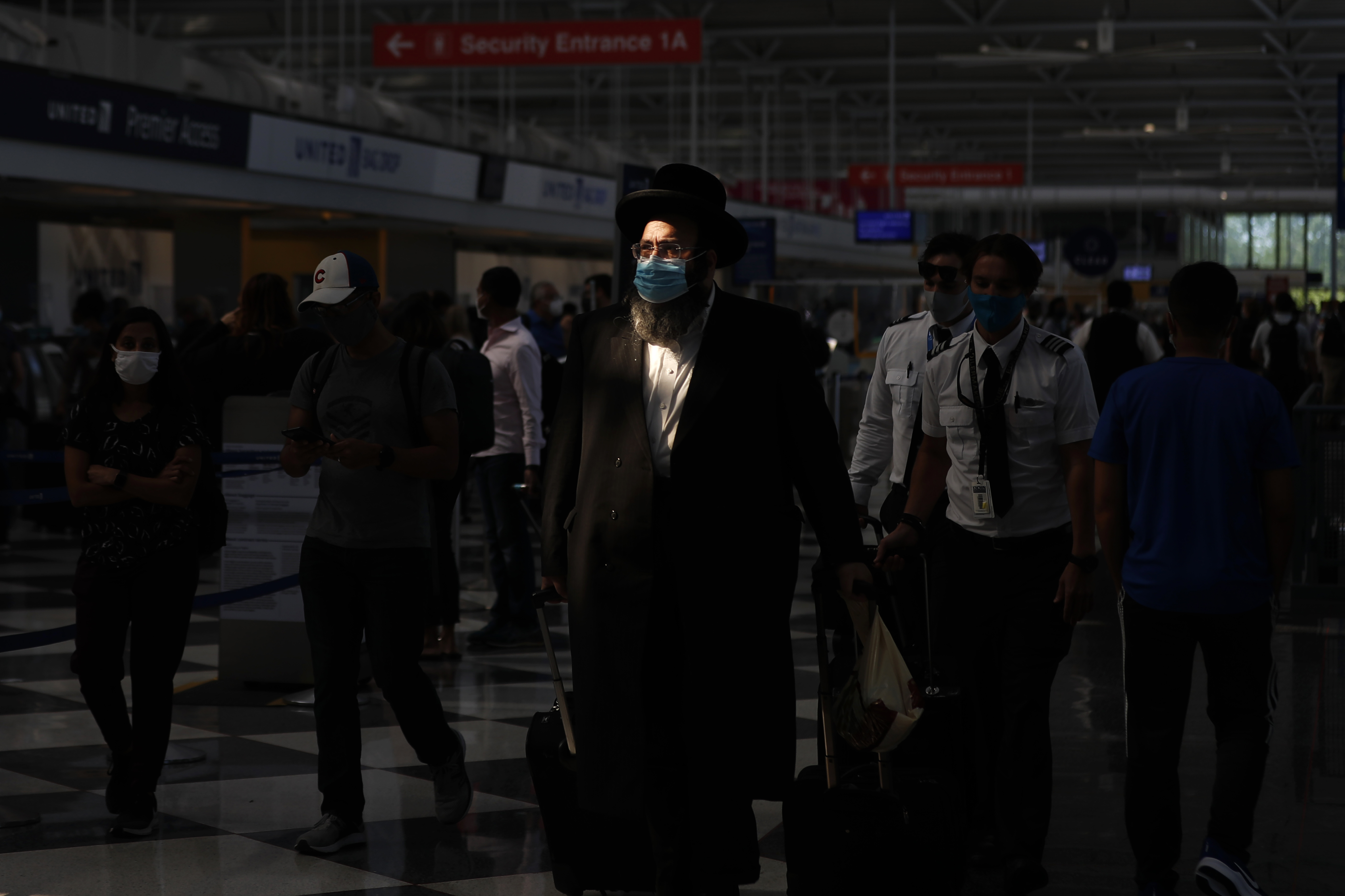 FILE - A shaft of light illuminates a passenger before boarding a flight at O'Hare International Airport in Chicago ahead of Fourth of July weekend, July 1, 2021. Loneliness in America can be deadly. In May 2023, U.S. Surgeon General Vivek Murthy declared it an American epidemic, saying that it takes as deadly a toll as smoking upon the population of the United States. “Millions of people in America are struggling in the shadows,