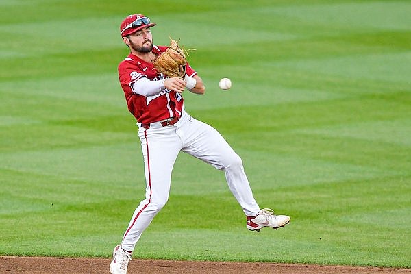 Arkansas shortstop John Bolton (9) throws to first after fielding a ground ball, Friday, April 28, 2023, during the first inning of the Razorbacks’ 10-4 win over the Texas A&M Aggies at Baum-Walker Stadium in Fayetteville.