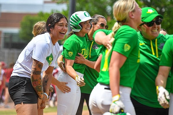 Oregon right fielder Ariel Carlson (3) celebrates with teammates and coaches, Sunday, May 21, 2023, following the Ducks’ 14-4 win over the Arkansas Razorbacks in the NCAA Fayetteville Regional championship at Bogle Park in Fayetteville.