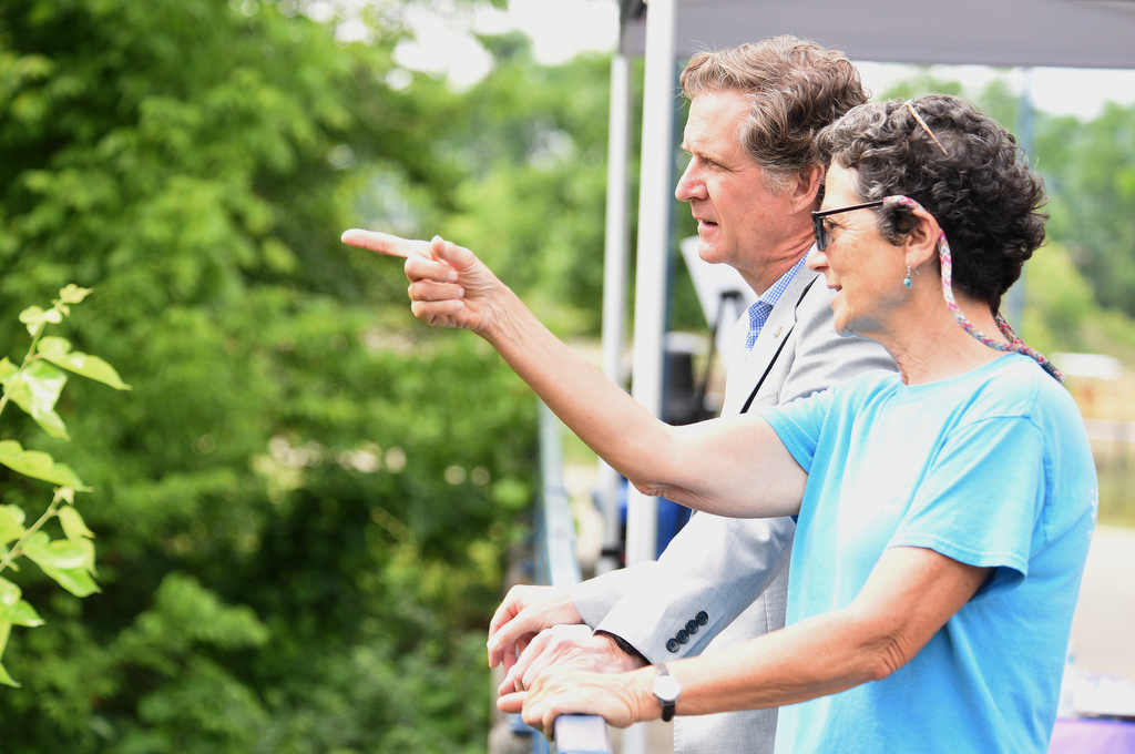 Staff photo by Matt Hamilton / WaterWays executive director Mary Beth Sutton, front, speaks with Mayor Tim Kelly on the Tennessee River Walk about the trash booms on Tuesday, May 23, 2023.