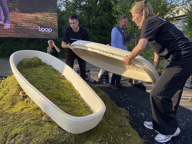 Director Lonneke Westhoff, right, and founder Bob Hendrikx, left, of Dutch startup Loop Biotech display one of the cocoon-like coffins, grown from local mushrooms and up-cycled hemp fibres, designed to dissolve into the environment amid growing demand for more sustainable burial practices, in Delft, Netherlands, Monday, May 22, 2023. A Dutch intrepid inventor is now “growing” coffins by putting mycelium, the root structure of mushrooms, together with hemp fiber in a special mold that, in a week, turns into what could basically be compared to the looks of an unpainted Egyptian sarcophagus. (AP Photo/Aleksandar Furtula)