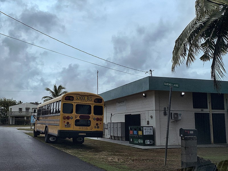A school bus waits at the side of the Mongmong-Toto-Maite community center to transport residents to public schools set up as emergency shelters, Tuesday, May 23, 2023, in Guam, ahead of Typhoon Mawar. (AP/Grace Garces Bordallo)