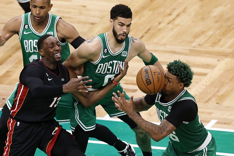 Boston Celtics guard Marcus Smart (right) is hit in the face by a loose ball as Miami Heat center Bam Adebayo (second from left) reaches for it and center Al Horford (left) watches along with forward Jayson Tatum during the second half in Game 5 of the NBA Eastern Conference finals on Thursday in Boston. The Celtics won 110-97 to narrow their series deficit to 3-2.
(AP/Michael Dwyer)