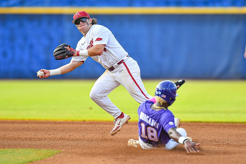 Arkansas second baseman Peyton Holt (top) fakes a throw to first base Thursday, opting instead to throw to third base, as LSU’s Tre Morgan slides into second base during the sixth inning of the Razorbacks’ victory over the Tigers in Hoover, Ala.
(NWA Democrat-Gazette/Hank Layton)