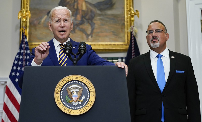 President Joe Biden speaks about student loan debt forgiveness in the Roosevelt Room of the White House, on Aug. 24, 2022, in Washington. Education Secretary Miguel Cardona listens at right. (AP Photo/Evan Vucci, File)