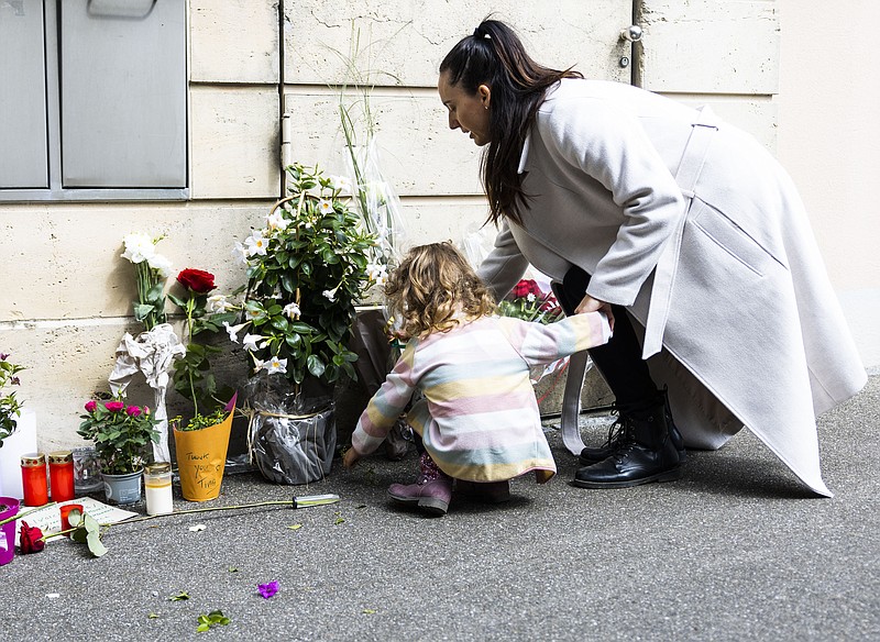 A mother and her daughter lay down flowers at the gate of the house of late singer and stage performer Tina Turner in Kuesnacht, Switzerland, on Thursday, May 25, 2023. Turner, the unstoppable singer and stage performer, died Wednesday, after a long illness at her home in Kuesnacht near Zurich, Switzerland, according to her manager. She was 83. (AP Photo/Arnd Wiegmann)