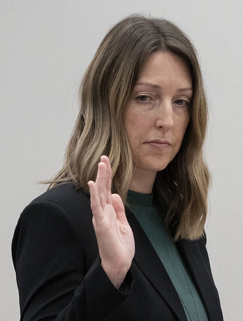 Dr. Caitlin Bernard raises her right hand as she is sworn in Thursday, May 25, 2023, during a hearing in front of the state medical board at the Indiana Government South building in downtown Indianapolis. Bernard is appearing before the board for the final hearing in a complaint filed by Attorney General Todd Rokita saying she violated patient privacy laws and reporting laws. (Mykal McEldowney/The Indianapolis Star via AP)