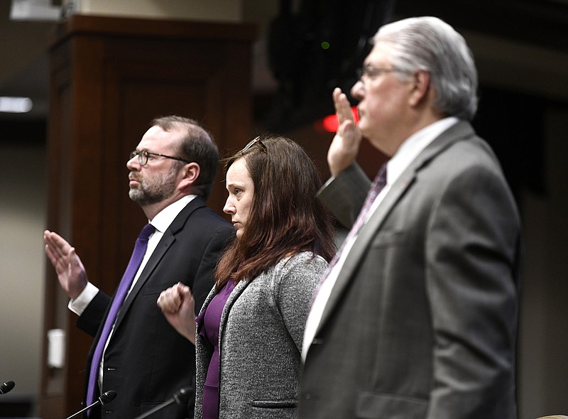 Steve Guntharp (from left), chief of staff of the Arkansas Department of Labor and Licensing, Kelli Black, director of the state Auctioneers Licensing Board, and Dan Parker, chief legal counsel for the state Department of Labor and Licensing, are sworn under oath before giving their testimony during a meeting of the Joint Performance Review Committee at the Multi-Agency Complex near the state Capitol on Wednesday.
(Arkansas Democrat-Gazette/Stephen Swofford)