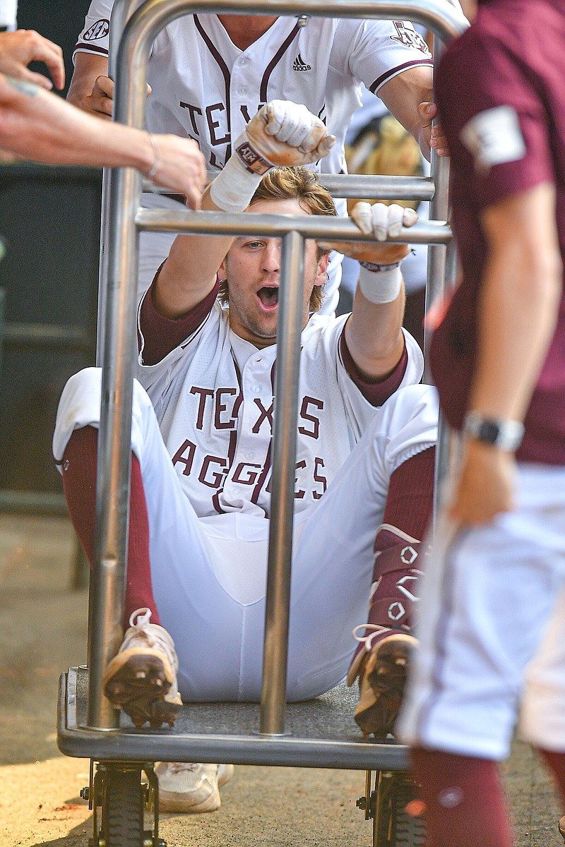 Texas A&M shortstop Hunter Haas celebrates in the dugout after hitting a go-ahead three-run home run in the bottom of the seventh inning against LSU on Friday in the SEC Baseball Tournament in Hoover, Ala. The Aggies won 5-4 and will play Arkansas at noon today in the semifinals.
(NWA Democrat-Gazette/Hank Layton)