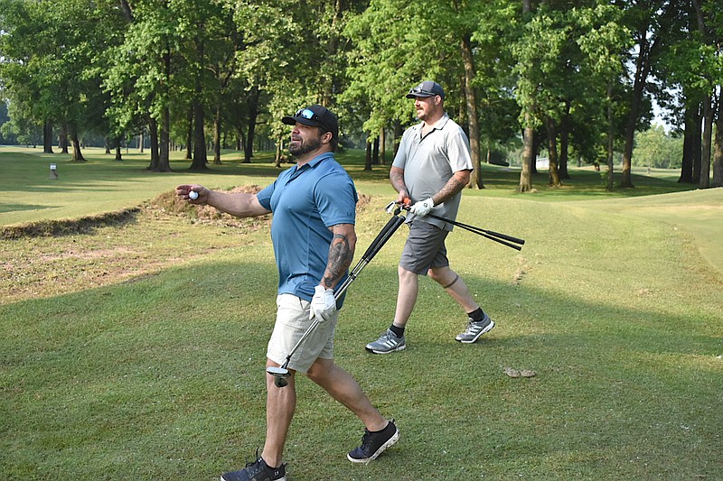 Bryan Clevenger, left, and Pryce Lybrand walk off the first green at Harbor Oaks on Friday. (Pine Bluff Commercial/I.C. Murrell)