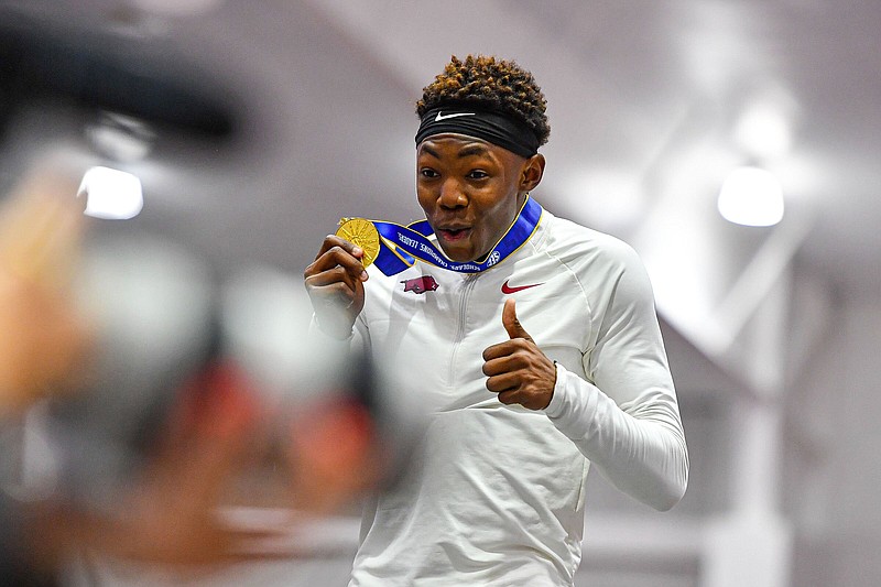 Arkansas triple-jumper Jaydon Hibbert holds his first-place medal during  the Razorbacks’ championship sweep at the SEC Indoor Track and Field Championships in February at the Randal Tyson Track Center in Fayetteville.
(NWA Democrat-Gazette/Hank Layton)