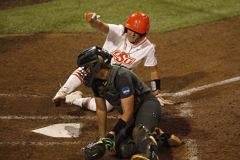 Oklahoma State’s Micaela Wark slides into home past Oregon catcher Terra McGowan during an NCAA super regional softball game Thursday in Stillwater, Okla. The Cowgirls took a 9-0 victory Friday to clinch a spot in the Women’s College World Series.
(AP/Garett Fisbeck)