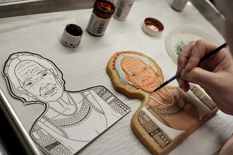 Jasmine Cho works on a cookie portrait of Filipina mambabatok tattoo artist Apo Whang-Od in Pittsburgh, Pa., Wednesday, May 3, 2023. Cho, a Korean American self-described “cookie activist,” has gained fans over the last several years for her finely detailed cookie mugs of famous and forgotten figures. (AP Photo/Matt Freed)