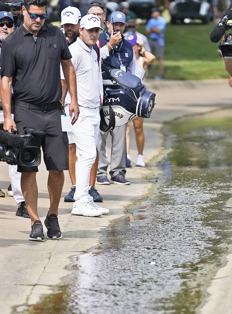 Emiliano Grillo watches as his ball floats down a concrete drainage canal on the 18th hole during Sunday's final round of the Charles Schwab Challenge at Colonial Country Club in Fort Worth, Texas. (Associated Press)
