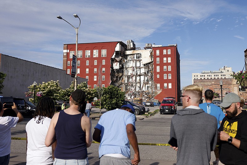 Onlookers watch as emergency crews work the scene of a partial building collapse on the 300 block of Main Street, Sunday, May 28, 2023, in Davenport, Iowa. (Nikos Frazier/Quad City Times via AP)