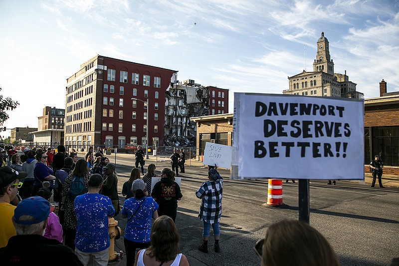 Davenport police officers form a line opposite protesters that are advocating for search efforts to continue, Tuesday, May 30, 2023, near the site of an apartment building that partially collapsed in Davenport, Iowa. (Joseph Cress/Iowa City Press-Citizen via AP)