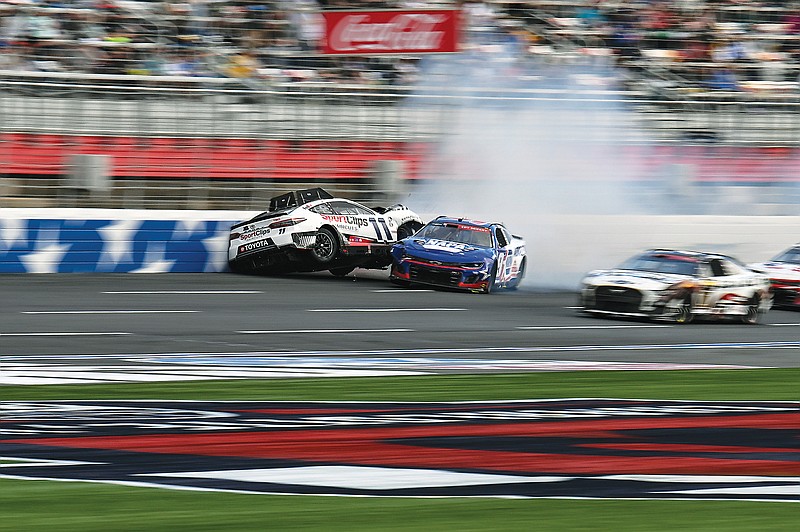 Chase Elliott (9) and Denny Hamlin (11) collide Monday during the NASCAR Cup Series race at Charlotte Motor Speedway in Concord, N.C. (Associated Press)