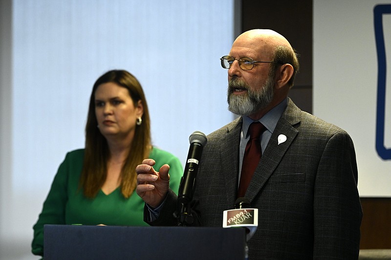 Then-Gov.-elect Sarah Huckabee Sanders (left) watches as Mike Mills speaks during a news conference in Little Rock in this Dec. 6, 2022 file photo. Sanders had just announced her plan to nominate Mills as Arkansas' secretary of Parks, Heritage, and Tourism. Sanders announced Friday, June 2, 2023 that Mills had resigned from the post, less than six months after the December announcement. (Arkansas Democrat-Gazette/Stephen Swofford)