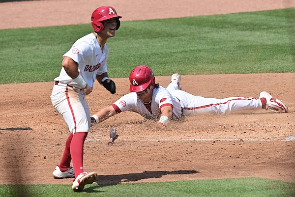 Arkansas second baseman Peyton Holt slides into home plate during the fourth inning of an NCAA regional game against Santa Clara on Friday, June 2, 2023, in Fayetteville.