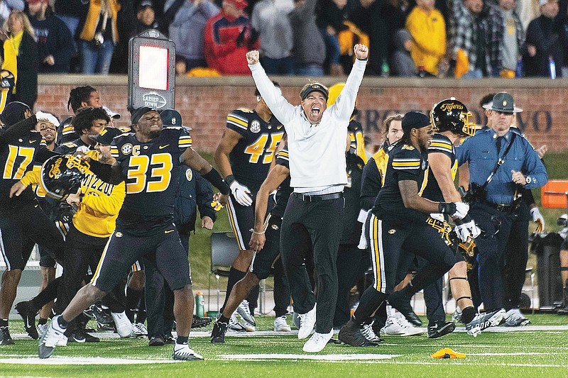 In this Nov. 25, 2022, file photo. Missouri coach Eli Drinkwitz leaps as players run onto the field after defeating Arkansas 29-27 at Faurot Field in Columbia. (Associated Press)