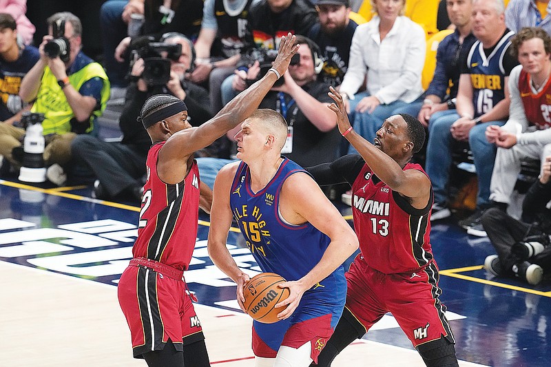Heat forward Jimmy Butler (left) and center Bam Adebayo (right) defend against Nuggets center Nikola Jokic during the first half of Thursday night’s Game 1 of the NBA Finals in Denver. (Associated Press)