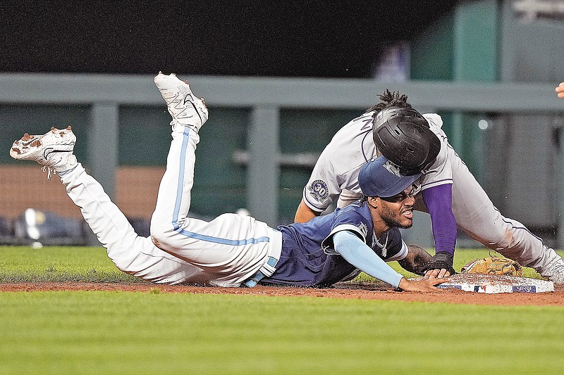 Elias Diaz of the Rockies collides at third with Royals third baseman Maikel Garcia after he got caught off base during the eighth inning of Friday night’s game at Kauffman Stadium in Kansas City. (Associated Press)