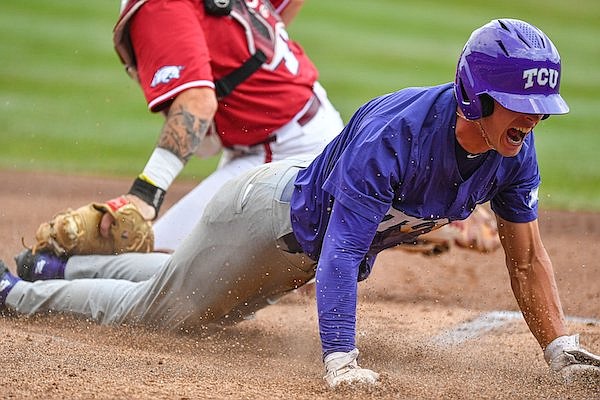 TCU designated hitter Kurtis Byrne (4) slides past Arkansas catcher Parker Rowland (44) to score, Sunday, June 4, 2023, during the first inning of the Razorbacks’ game against TCU in the second round of the NCAA Fayetteville Regional at Baum-Walker Stadium in Fayetteville.