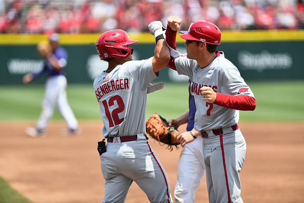 Arkansas' Tavian Josenberger (12) is shown with first base coach Bobby Wernes on Monday, June 5, 2023, during an NCAA Fayetteville Regional game against TCU at Baum-Walker Stadium.
