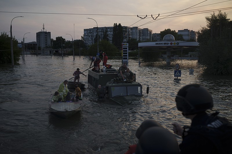 Residents are evacuated from a flooded neighborhood in Kherson, Ukraine, Tuesday, June 6, 2023. A major dam in southern Ukraine has collapsed, flooding villages, endangering crops in the country's breadbasket and threatening drinking water supplies. (AP Photo/Felipe Dana)
