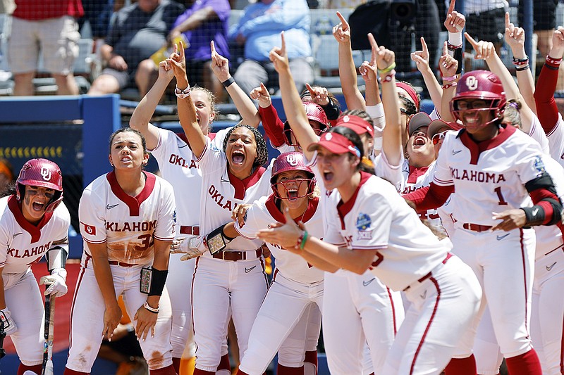 Oklahoma players cheer as they wait at home plate for Tiare Jennings after Jennings hit a 3-run home run during Saturday's game against Tennessee in the Women's College World Series in Oklahoma City. (Associated Press)