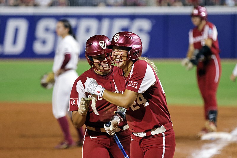 Oklahoma teammates Alyssa Brito (left) and Jayda Coleman celebrate Wednesday night after Coleman scored a run during the fifth inning of a Women's College World Series game against Florida State in Oklahoma City. (Associated Press)