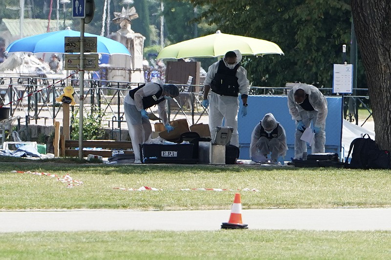 Police officers investigate at the scene after a knife attack Thursday, June 8, 2023 in Annecy, French Alps. A man with a knife stabbed several very young children, including at least one in a stroller, and also assaulted adults in a lakeside park in the French Alps. The savagery left at least two children and one adult with life-threatening injuries, authorities said. (AP Photo/Laurent Cipriani)
