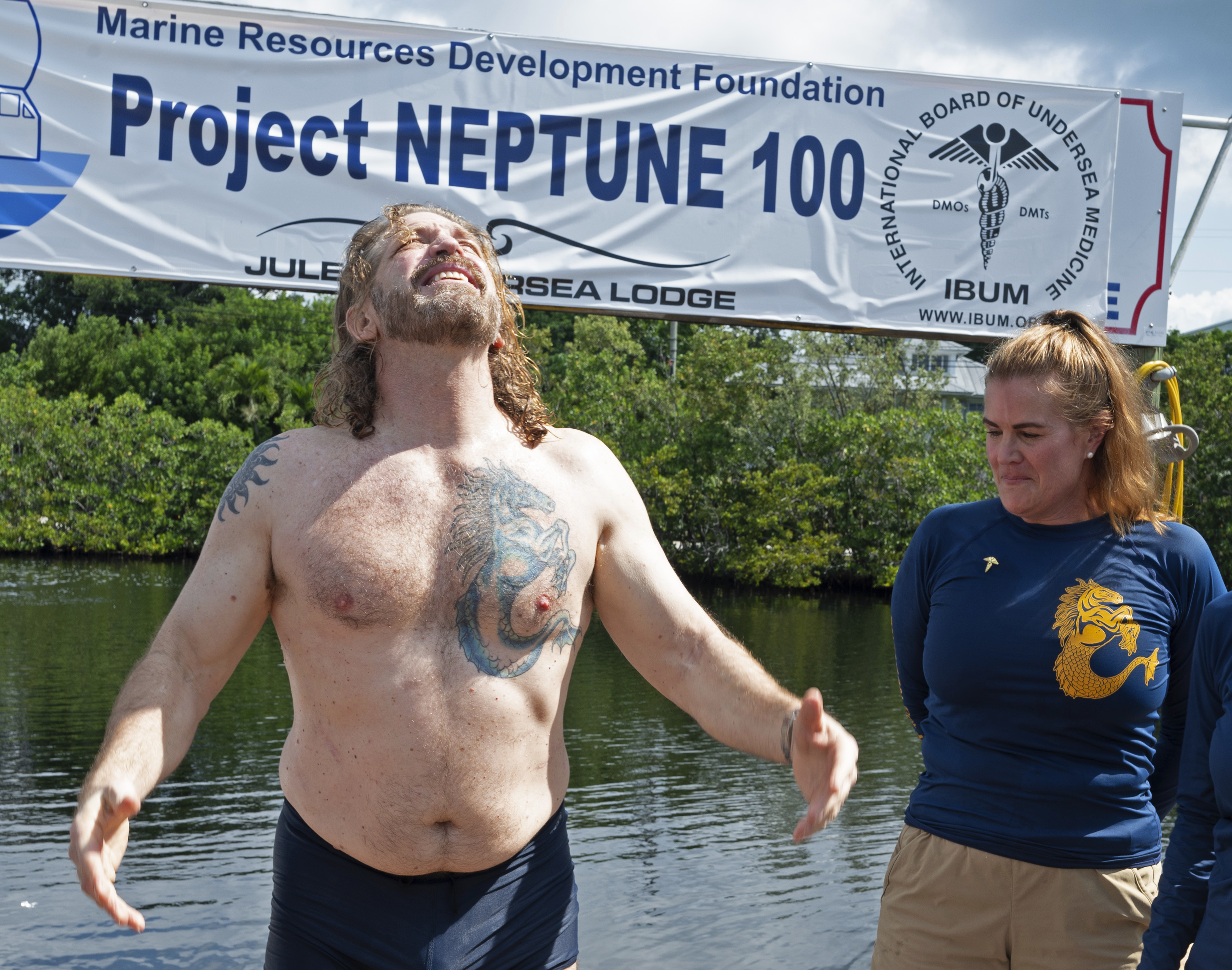 In this photo provided by the Florida Keys News Bureau, diving explorer and medical researcher Dr. Joseph Dituri, left, basks in the sun Friday, June 9, 2023, after completing a 100-day underwater mission in the Jules' Undersea Lodge marine habitat at the bottom of a lagoon in Key Largo, Fla. Dituri broke the previous 73-day record for underwater human habitation at ambient pressure, undertook medical and marine science research and interacted online with more than 5,500 students during his Project Neptune 100 mission organized by the Marine Resources Development Foundation. (Andy Newman/Florida Keys News Bureau via AP)