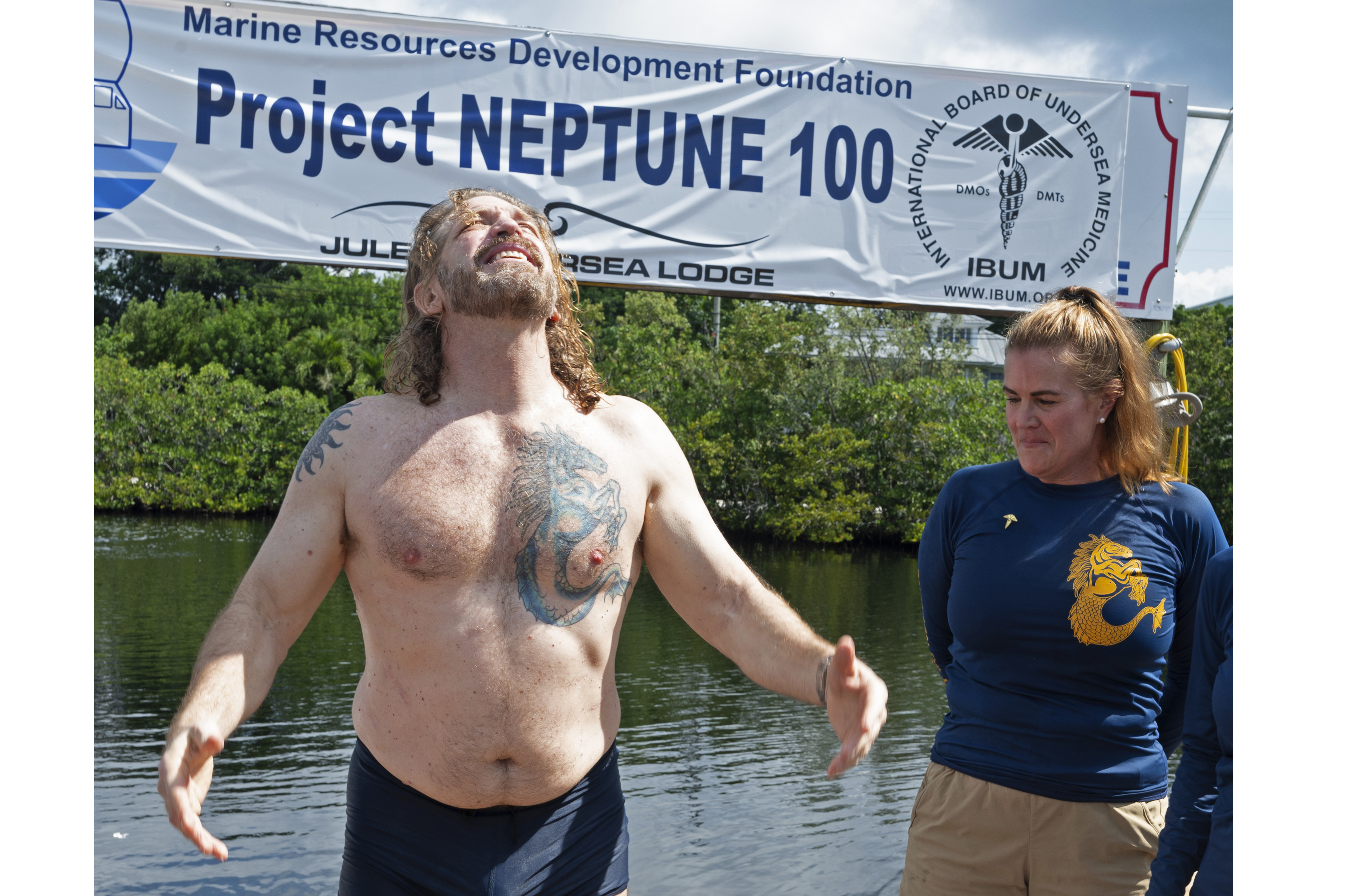 In this photo provided by the Florida Keys News Bureau, diving explorer and medical researcher Dr. Joseph Dituri, left, basks in the sun Friday, June 9, 2023, after completing a 100-day underwater mission in the Jules' Undersea Lodge marine habitat at the bottom of a lagoon in Key Largo, Fla. Dituri broke the previous 73-day record for underwater human habitation at ambient pressure, undertook medical and marine science research and interacted online with more than 5,500 students during his Project Neptune 100 mission organized by the Marine Resources Development Foundation. (Andy Newman/Florida Keys News Bureau via AP)