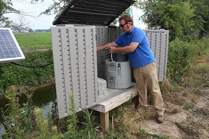 Lee Riley, program associate with University of Arkansas Division of Agriculture Cooperate Extension Service, Crop, Soil & Environmental Science department, checks a water monitoring system at Pratt Farm in Light on Wednesday.
(Arkansas Democrat-Gazette/Cristina LaRue)