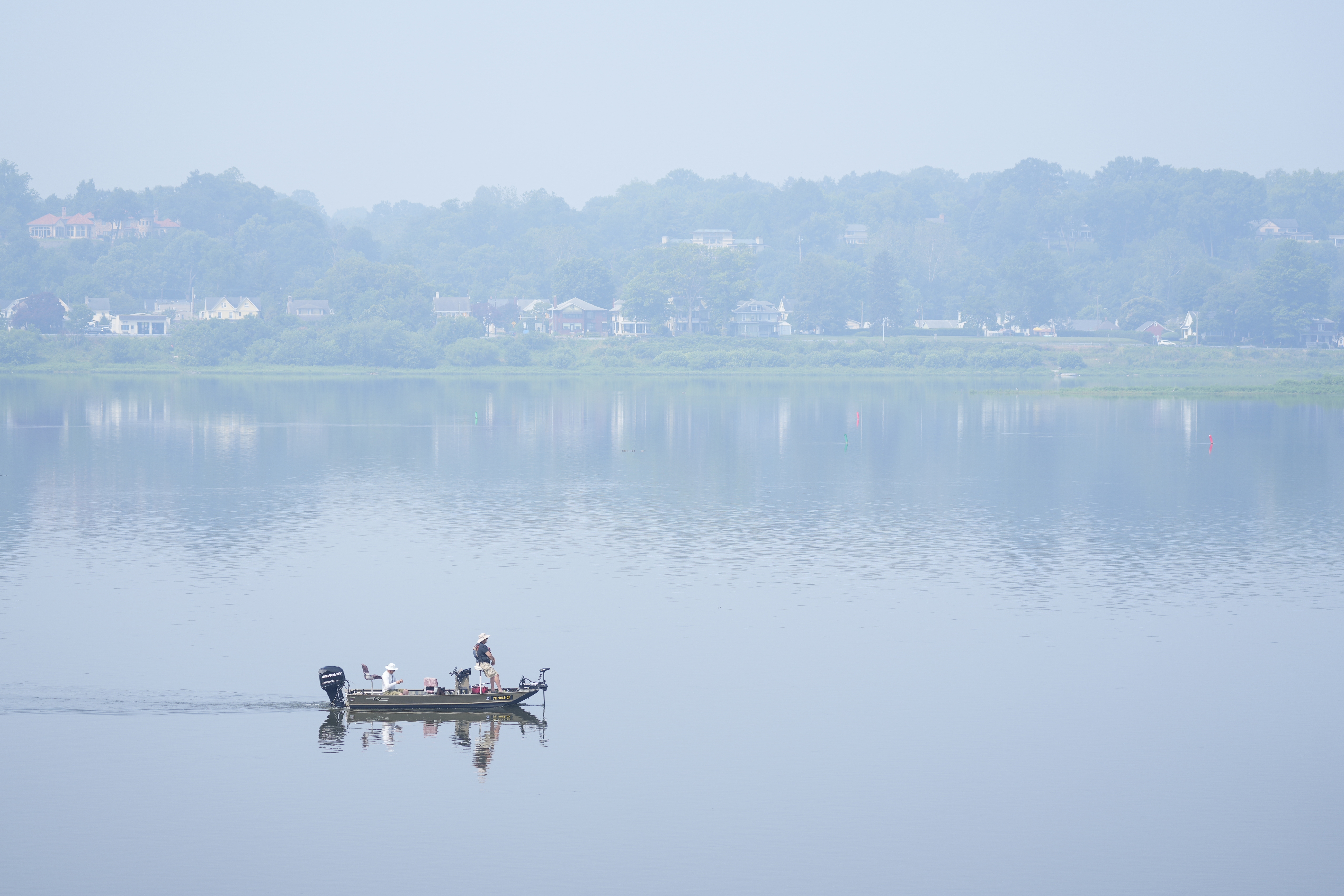 FILE - People fish on the Susquehanna River amidst haze from Canadian wildfires, June 29, 2023, in Harrisburg, Pa. As smoky as the summer has been so far, scientists say it will likely be worse in future years because of climate change. (AP Photo/Matt Rourke, File)