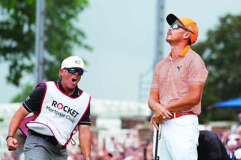 Rickie Fowler looks skyward as his caddie Ricky Romano yells after Fowler’s win on the first playoff hole during Sunday’s final round of the Rocket Mortgage Classic at Detroit Country Club. (The Associated Press)