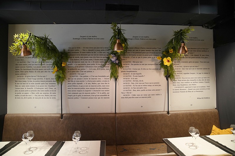 Flowers permanently hang on an extract from Milan Kundera’s theater piece “Jacques et son Maitre” in a restaurant near his home Wednesday in Paris.
(AP/Christophe Ena)