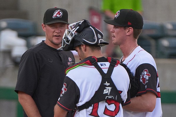 Coach, pitcher and catcher discussing the progress of the Little