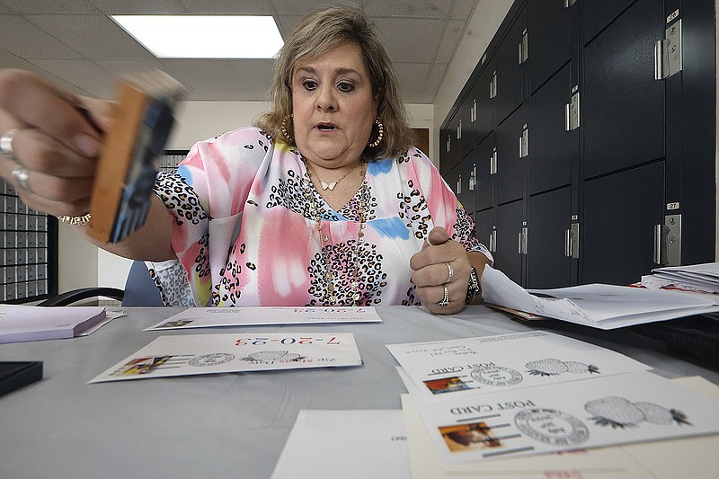 Julie Chudy, customer service relations coordinator for the U.S. Postal Service, stamps “date meets ZIP” cancellations on postcards on Thursday at the Cabot Post Office.
(Arkansas Democrat-Gazette/Thomas Metthe)