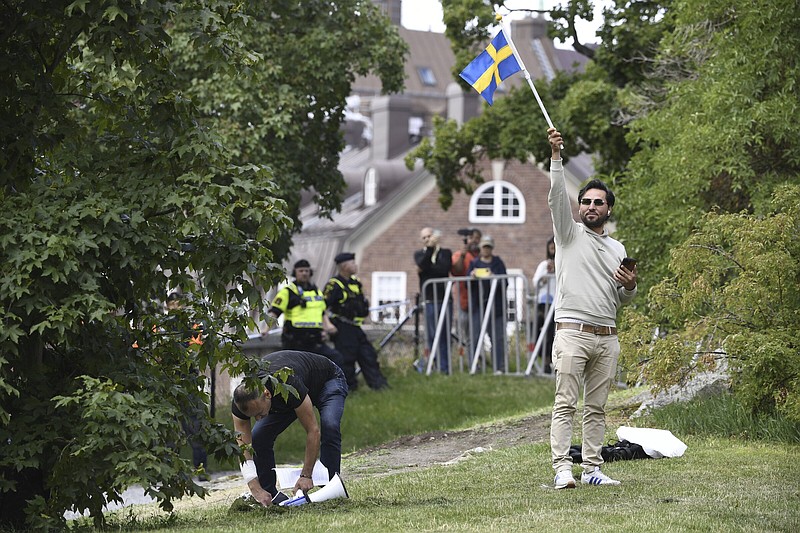 Protestor Salwan Momika waves the Swedish flag Thursday outside the Iraqi Embassy in Stockholm, where he planned to burn a copy of the Koran and the Iraqi flag. Video at arkansasonline.com/721embassy/.
(AP/TT/Oscar Olsson)
